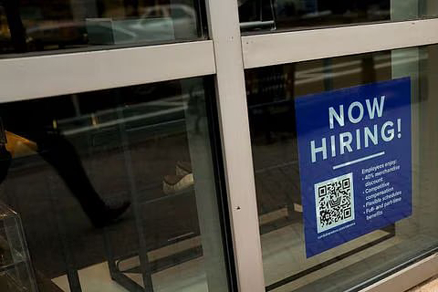 An employee hiring sign with a QR code is seen in a window of a business in Arlington, Virginia, US, Apr 7, 2023.
