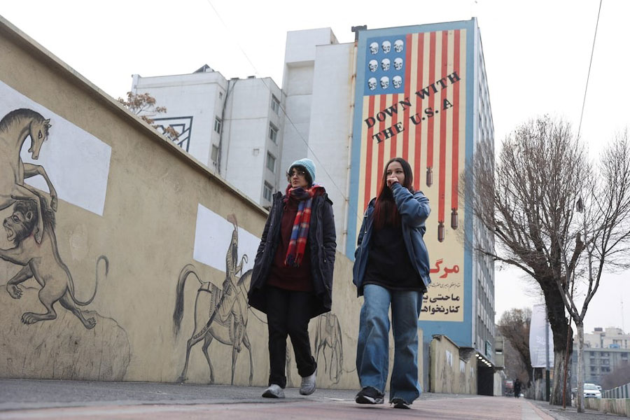 People walk next to an anti-US mural in Tehran.