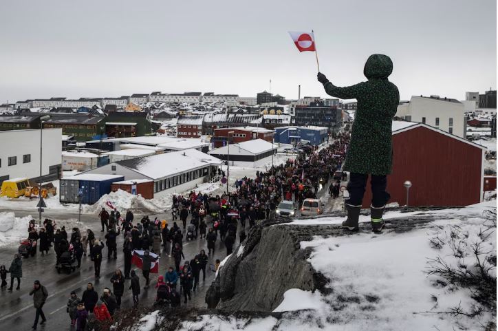 A woman waves a Greenlandic flag as people attend a protest against U.S. President Donald Trump's demand that the Arctic island be ceded to the U.S., calling for it to be allowed to determine its own future, in Nuuk, Greenland, January 17. REUTERS/Marko Djurica