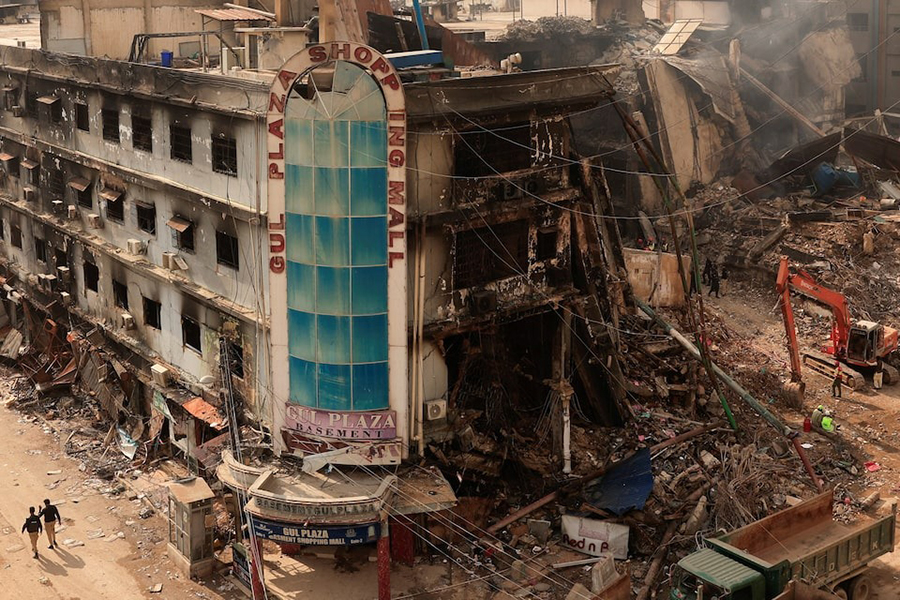 Police officers walk past the aftermath of a massive fire that broke out at the Gul Plaza Shopping Mall in Karachi, Pakistan on January 22, 2026 — Reuters photo
