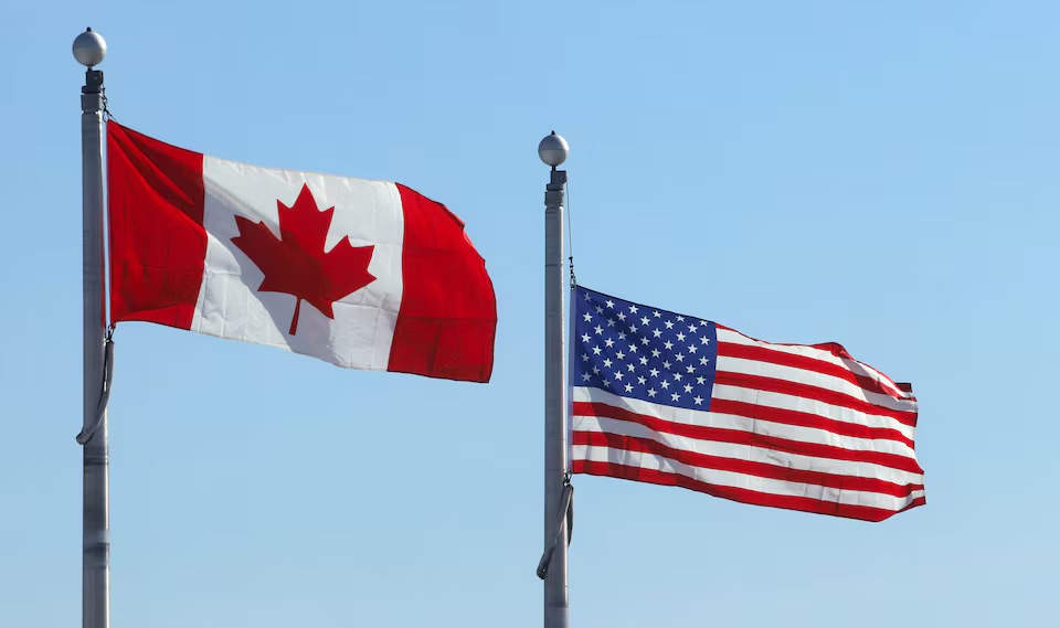 The Canadian and U.S. flags flutter at the Lansdowne Port of Entry next to the Thousand Islands Bridge in Lansdowne, Ontario, Canada February 12, 2025. REUTERS/Patrick Doyle/File Photo