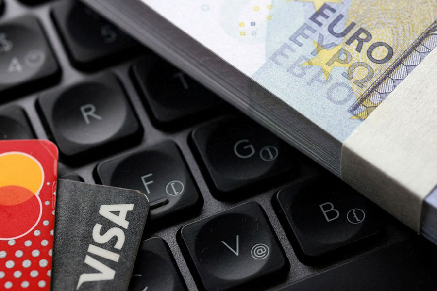 Representational image: Euro banknotes, Visa and Mastercard cards are placed on a keyboard in this illustration taken Sept 24, 2025.