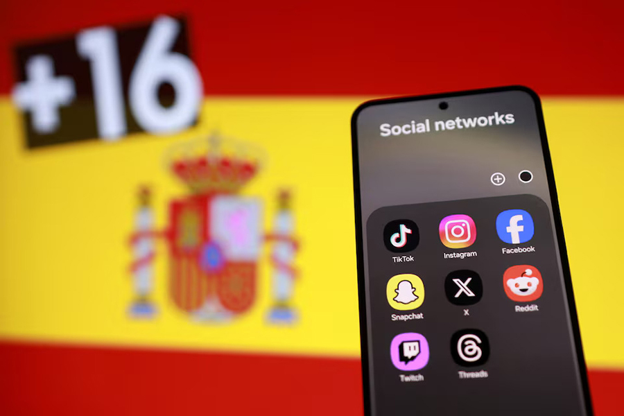 A Spanish flag, smartphone with displayed social media app icons and text "+16" in this illustration taken on February 3, 2026 — Reuters illustration/File