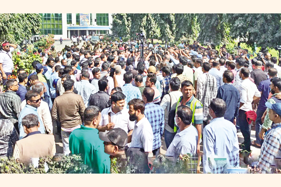 Workers seen demonstrating as Shipping Adviser Brig Gen (retd) M Sakhawat Hussain arrived at the Chittagong Port Thursday morning to find a solution to the ongoing stalemate over government move to appoint DP World as operator of the New Mooring Container Terminal (NCT). — FE photo