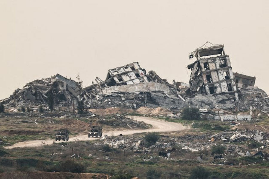 Israeli military vehicles drive past destruction in Gaza, as seen from the Israeli side of the Israel-Gaza border in southern Israel, January 21, 2026.