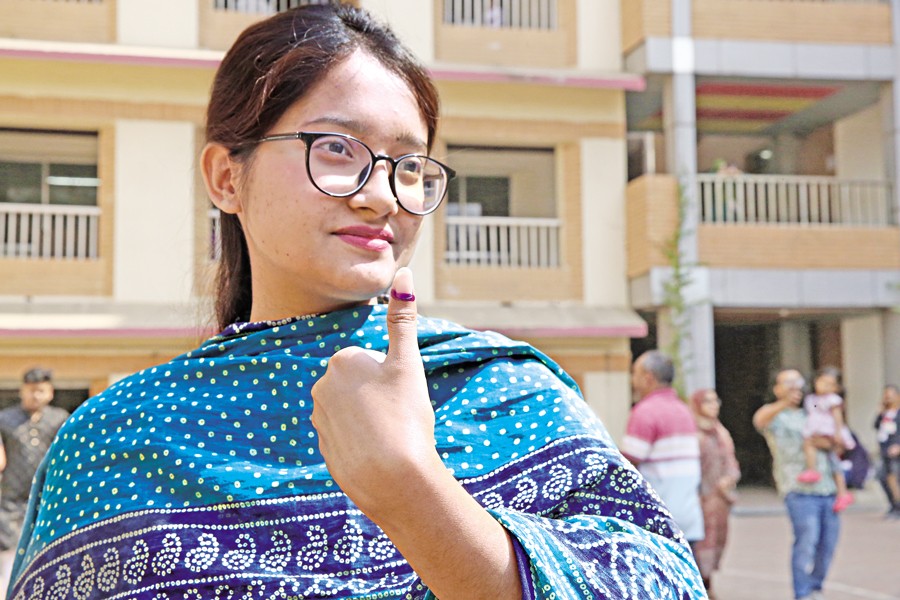 A young voter shows the indelible ink on her left thumb to express the joy of voting for the first time at the Monipur High School and College centre in the capital's Mirpur Thursday — FE photo