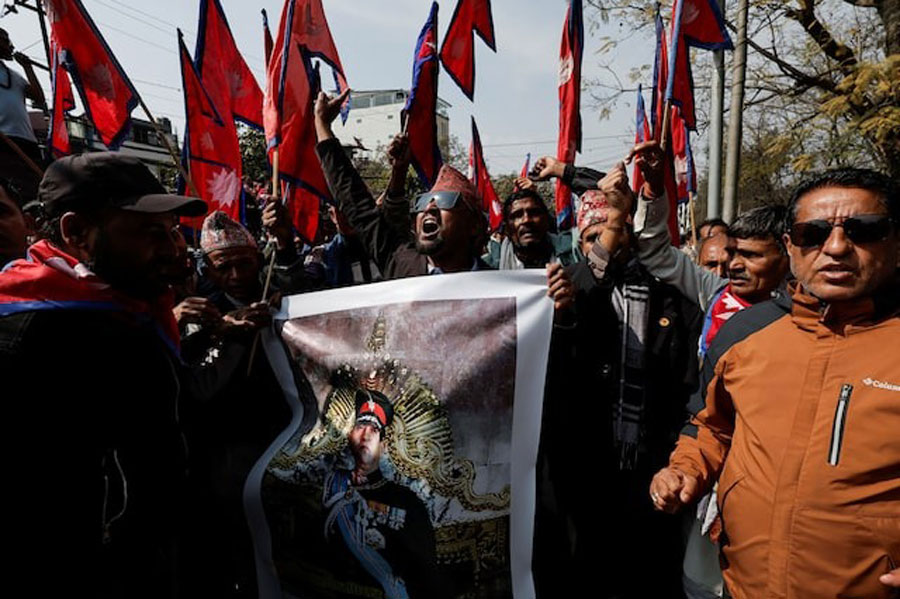 Pro-monarchy supporters holding a portrait of former King of Nepal Gyanendra Bir Bikram Shah Dev, chant slogans as they wait to welcome him in Kathmandu, Nepal, February 13, 2026.