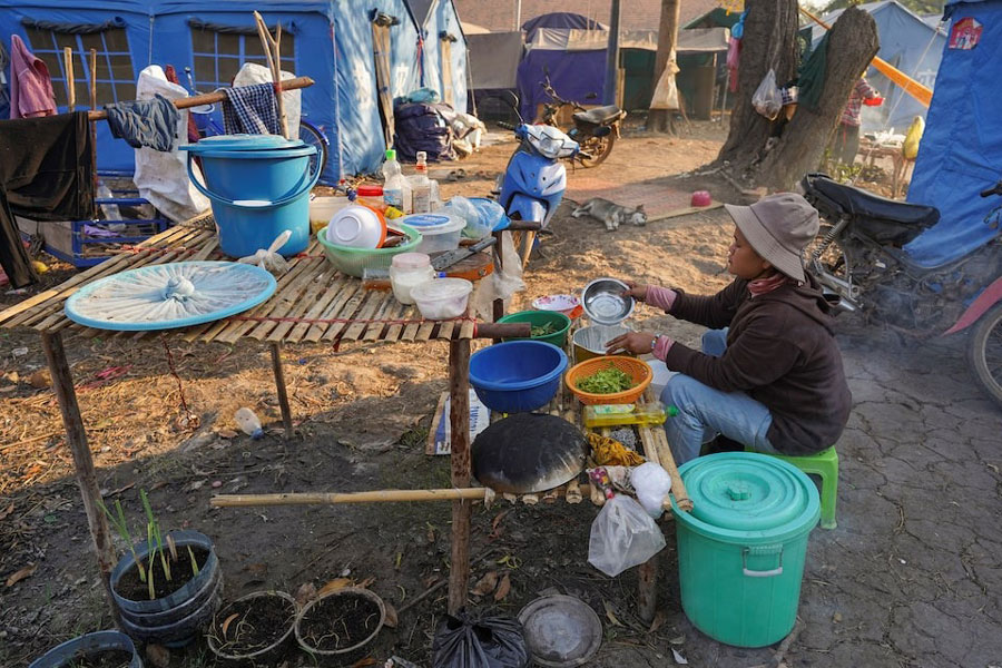 A woman prepares food at Wat Chansi refugee camp, where residents from Prey Chan village and Chouk Chey village have been staying since clashes between Thailand and Cambodia, in Banteay Meanchey province, Cambodia, February 11, 2026.