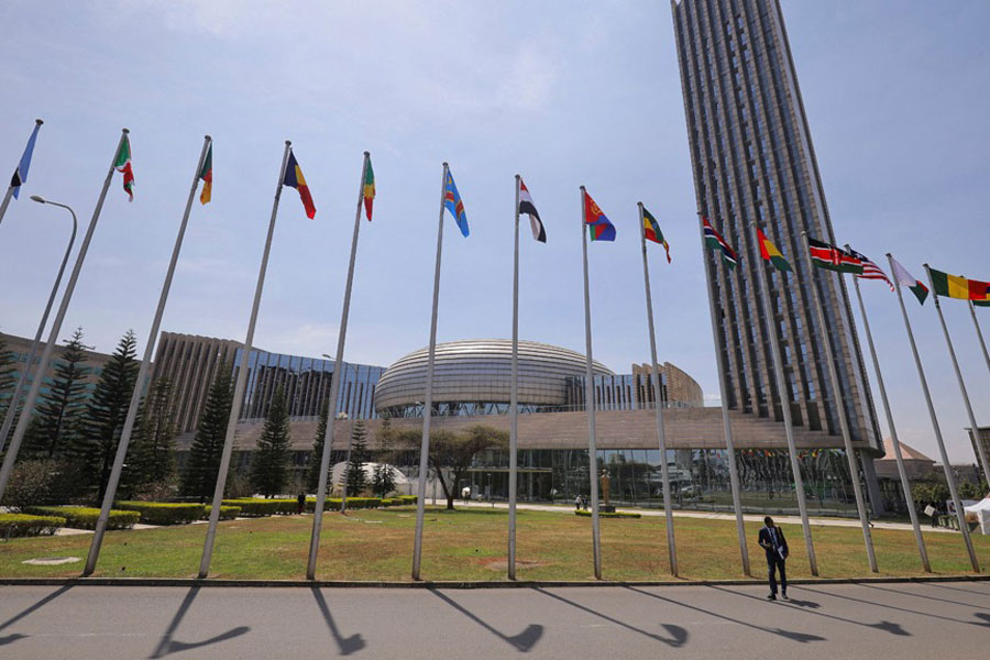 A delegate walks next to African Union (AU) member states flags ahead of the 38th Ordinary Session of the Heads of State and Government of the African Union at the African Union Commission (AUC) headquarters in Addis Ababa, Ethiopia, Feb 14, 2025.