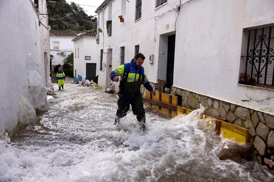 Workers walk along a flooded street after heavy rains, as Storm Marta hits parts of Spain, in Ubrique, Spain, February 8, 2026.