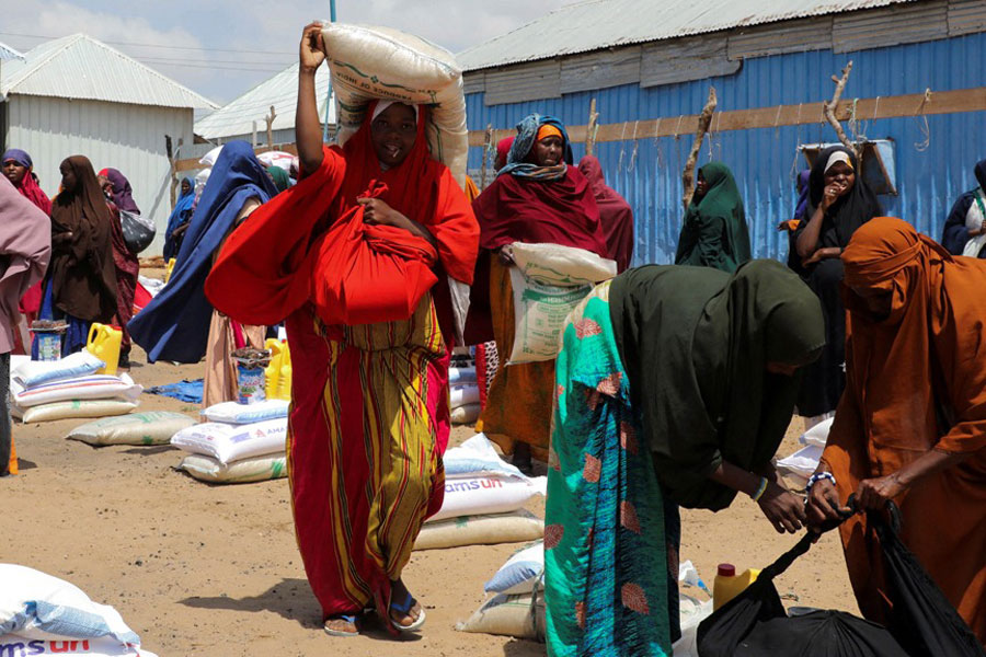 Internally displaced Somali women carry their relief packages after receiving dry relief food from Kuwait charity, during the Muslim holy fasting month of Ramadan, in Mogadishu, Somalia Mar 12, 2025.