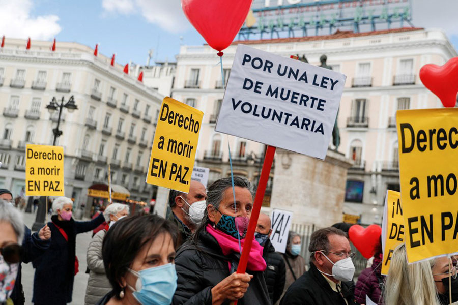 Supporters of a law to legalise euthanasia gather as the Spanish Parliament votes to approve it in Madrid, Spain, Mar 18, 2021. The banners read: "Right to die in peace", "For a law to die voluntarily" REUTERS/Susana Vera/F