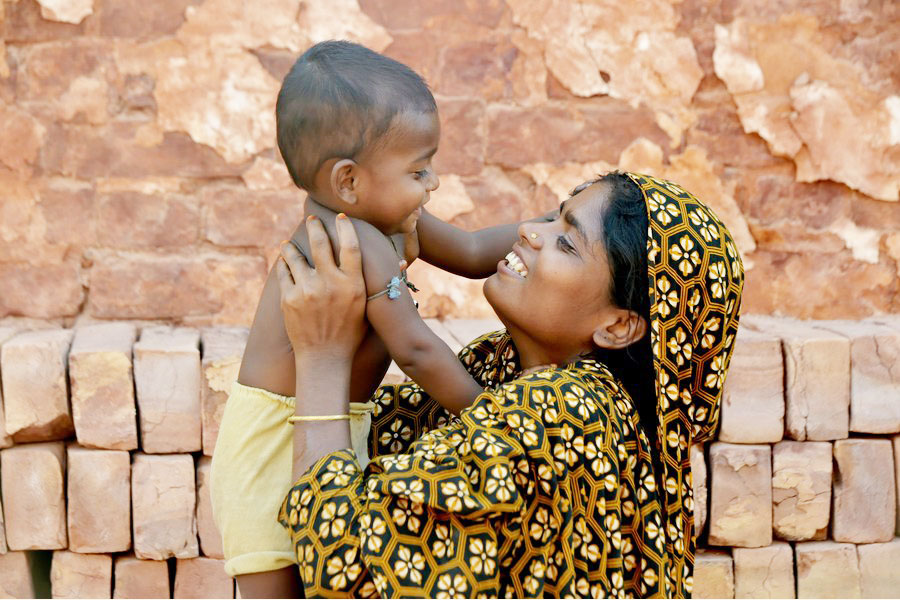 A female worker has a light moment with a child near a brickfield in Manikganj, Bangladesh. More than 1.6 million children suffer from malnutrition today in the country —Xinhua Photo