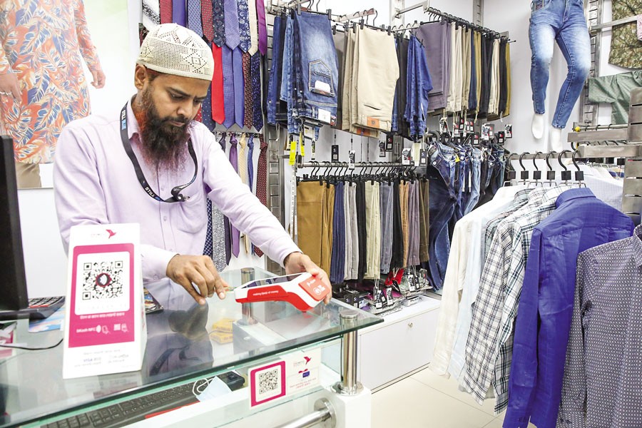 A salesperson receives payment through a PoS machine at a store in Dhaka — FE photo