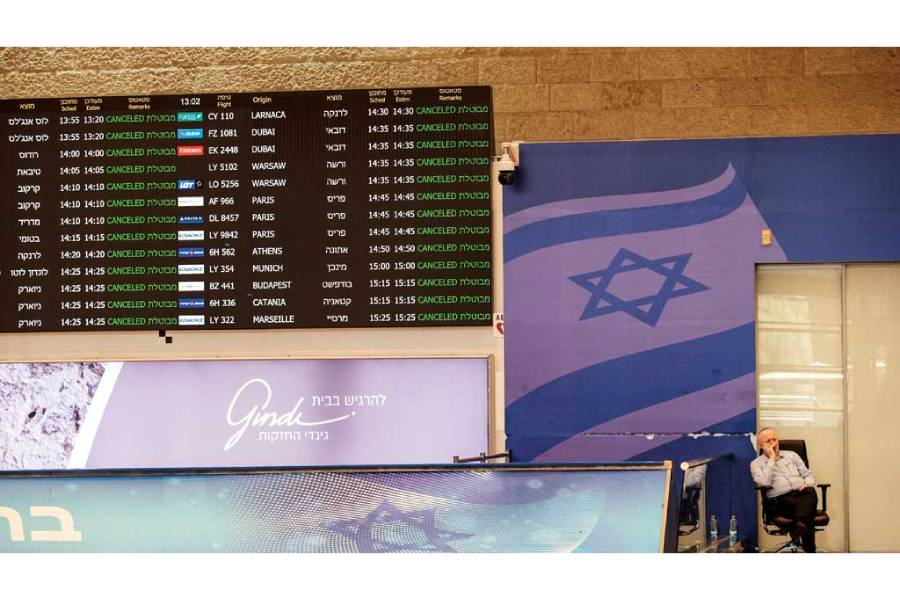 A worker at Ben Gurion International Airport in Israel sits at the arrivals terminal as all flights from and to the airport are indicated cancel, following an Israeli attack on Iran, Jun 13, 2025