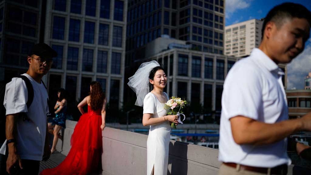 Couples prepare to get their photo taken during a wedding photography shoot on a street, in Shanghai, China Sept 6, 2023. REUTERS