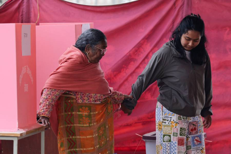 Ool Maya Maharjan, 93, accompanied by her granddaughter Aarya Maharjan, 22, walks after casting a vote during the general election, in Kathmandu, Nepal, Mar 5, 2026.