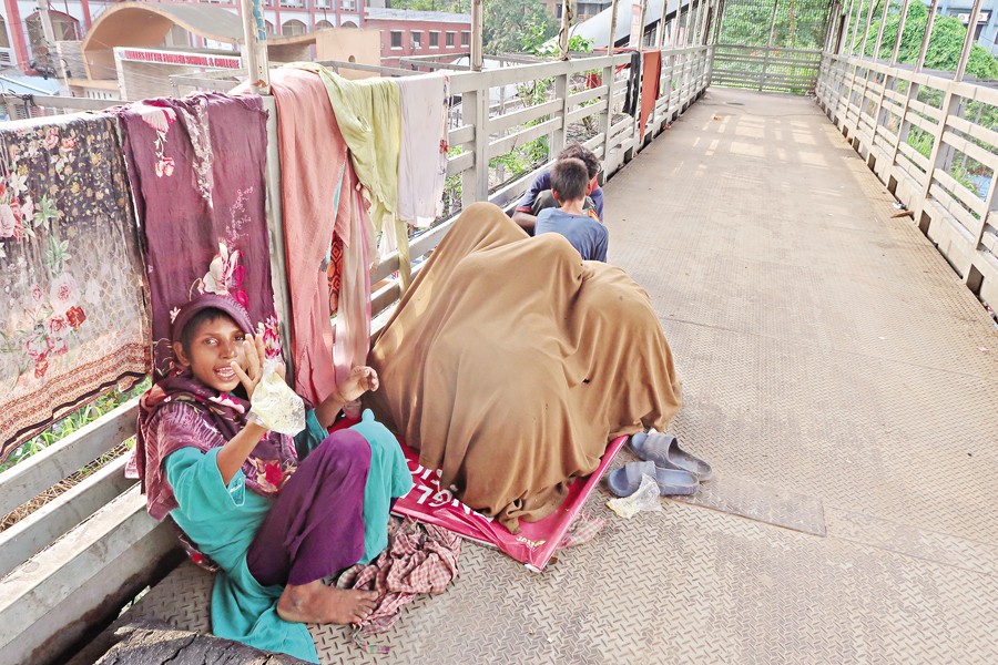 Some street urchins sniffing 'dandy' (a type of glue) as a cheap drug on the Kakrail Footover Bridge in the capital recently. — FE Photo