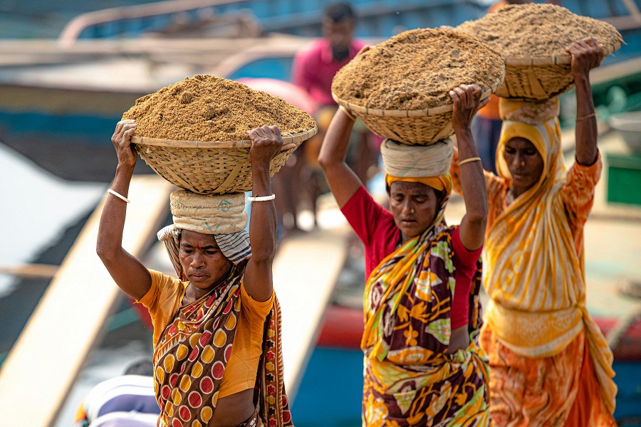 Bangladeshi women workers carrying sand on head