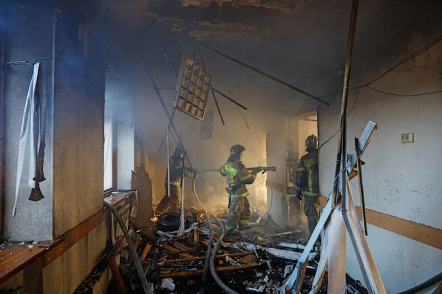 Firefighters work inside a building of a children's hospital, damaged by recent shelling that local Russian-installed authorities called a Ukrainian military strike, while the hospital was under maintenance with no patients inside, in the course of the Russia-Ukraine military conflict in Donetsk, a Russian-controlled city of Ukraine, March 8, 2026.