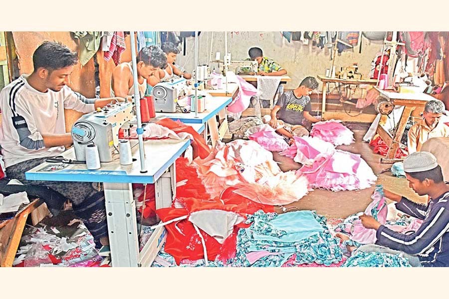 Workers pass busy times making dresses at a tailoring shop in Chattogram city. — FE Photo