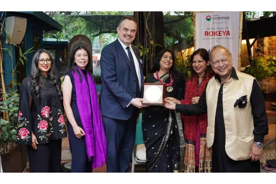 US Ambassador to Bangladesh Brent T. Christensen presents a crest to Ekushey Padak-winning artist Dr Rokeya Sultana at the Garden Gallery of Gallery Cosmos in the capital on Sunday.