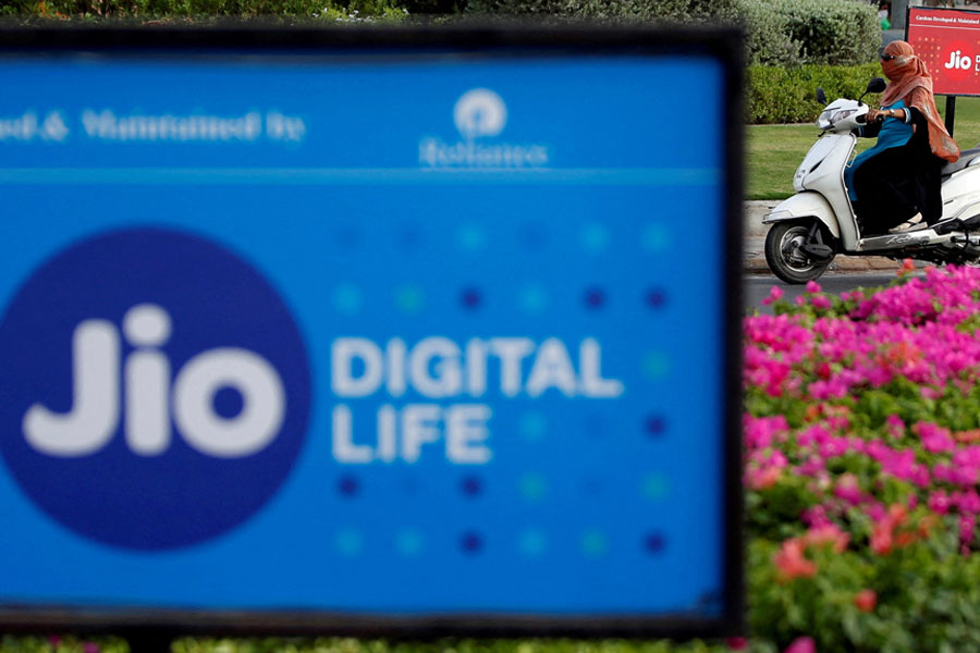 A woman rides her scooter past advertisements of Reliance Industries' Jio telecoms unit, in Ahmedabad, India, Jul 5, 2018.