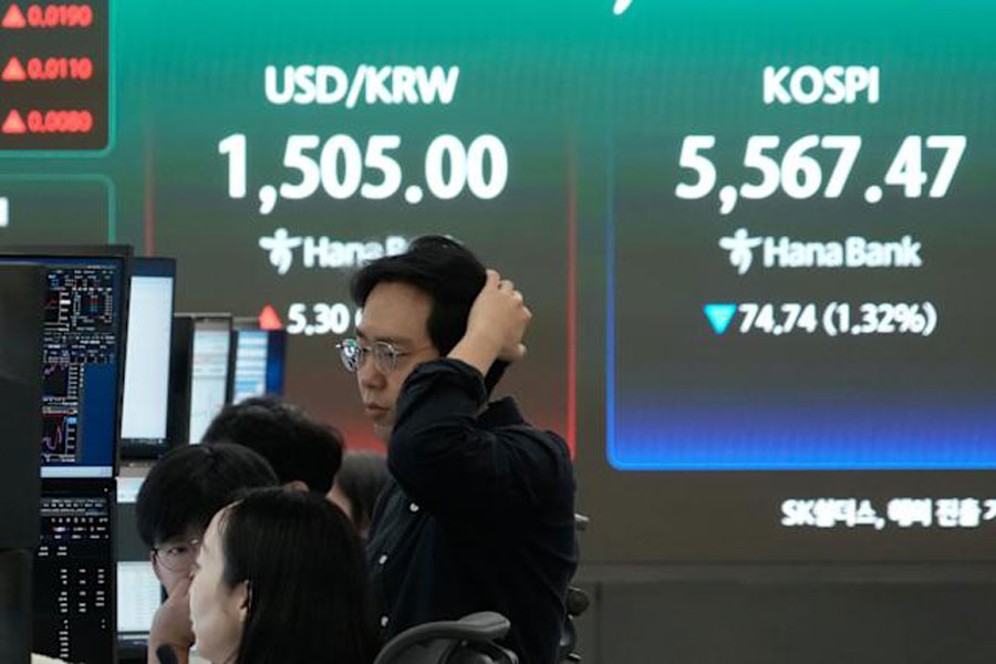 Currency traders watch monitors near a screen showing the Korea Composite Stock Price Index (KOSPI), right, and the foreign exchange rate between US dollar and South Korean won at the foreign exchange dealing room of the Hana Bank headquarters in Seoul, South Korea, Thursday, March 26, 2026.