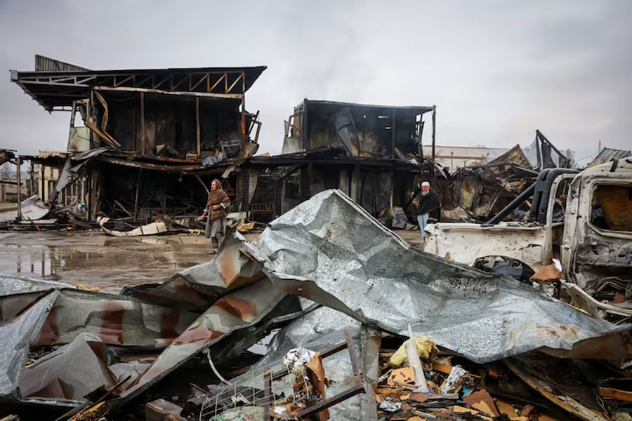 Afghan men walk next to debris lying at the site of a drug rehabilitation center destroyed in what the Taliban said was a Pakistani air strike in Kabul, Afghanistan, Mar 18, 2026.