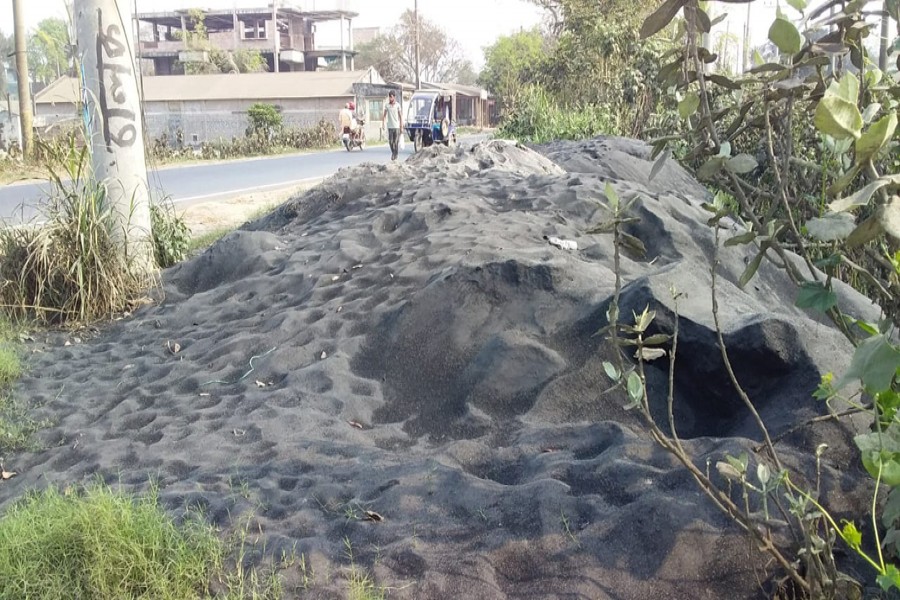Ashes from a husking mill which burns polythene in paddy processing has piled up beside the road in Joynagar of Ishwardi, posing risks to the environment and public health- FE Photo