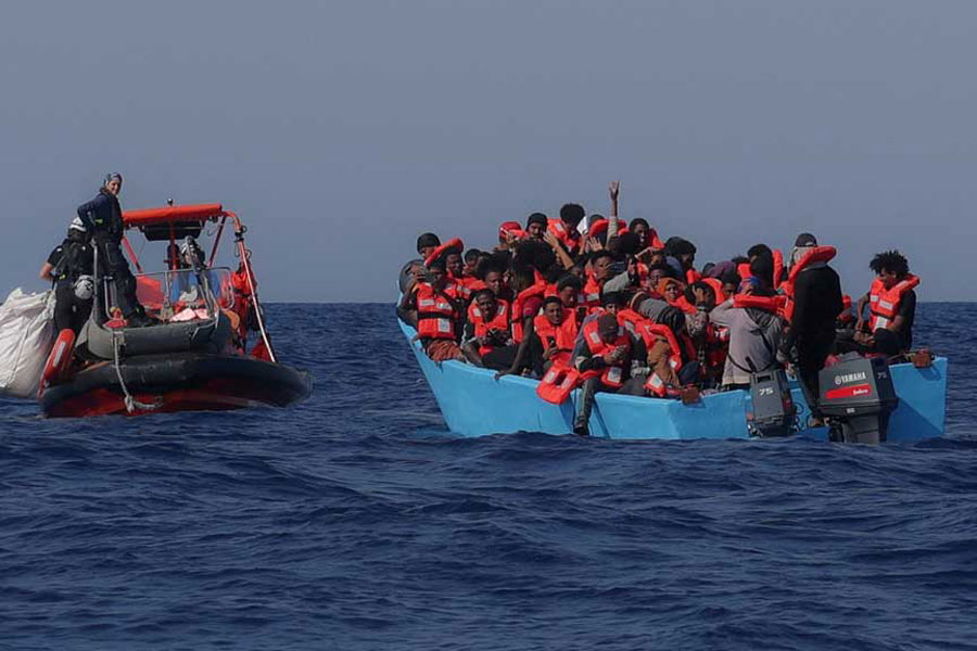 Migrants aboard an overcrowded boat react as they are approached by the crew of the migrant search and rescue ship Sea-Watch 5, operated by the German NGO Sea-Watch, during a rescue operation in the Search and Rescue (SAR) zone in the central Mediterranean, off Libya, Aug 11, 2025.