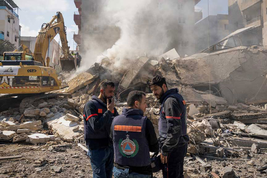 Rescue workers stand next to the rubble at the site of an Israeli strike in Tyre, Lebanon, Apr 8, 2026.