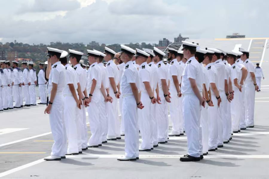 Sailors stand on board HMAS Canberra, facing the Sydney Opera House and the Sydney Harbour Bridge, ahead of the Kakadu International Fleet Review, a biennial maritime exercise marking 125 years of the Australian Navy, in Sydney, Australia, March 21, 2026.