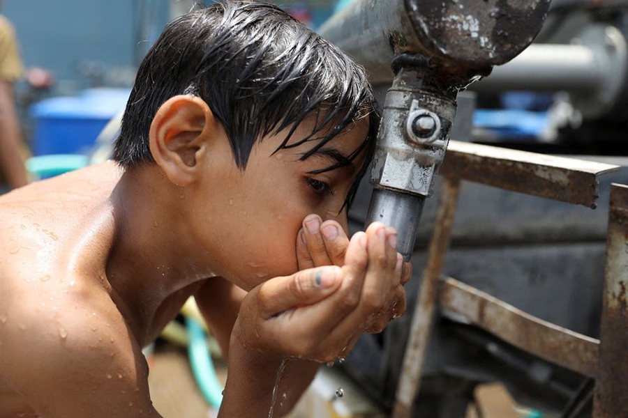 A boy drinks water from a municipal tanker on a hot summer day in New Delhi, India in this undated Reuters photo