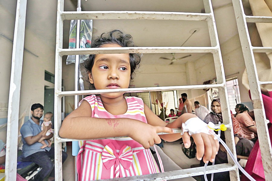 With saline needle attached to her hand, four-year-old Raisa gazes out of the window at Mugda General Hospital in Dhaka on July 13 this year as she now feels better after undergoing treatment for dengue. —FE file photo by KAZ Sumon