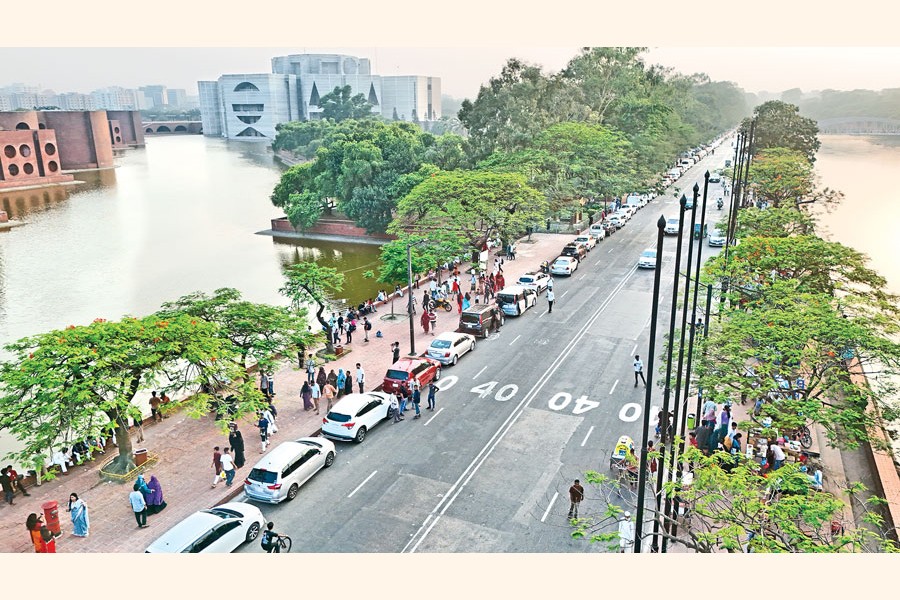Drivers wait in long queues stretching from Khamarbari to Asadgate in the capital for hours to refuel their vehicles on Friday. The photo was taken from the Crescent Lake Road in the Jatiya Sangsad Bhaban area in the afternoon. — FE Photo by K Asad-Uz-Zaman
