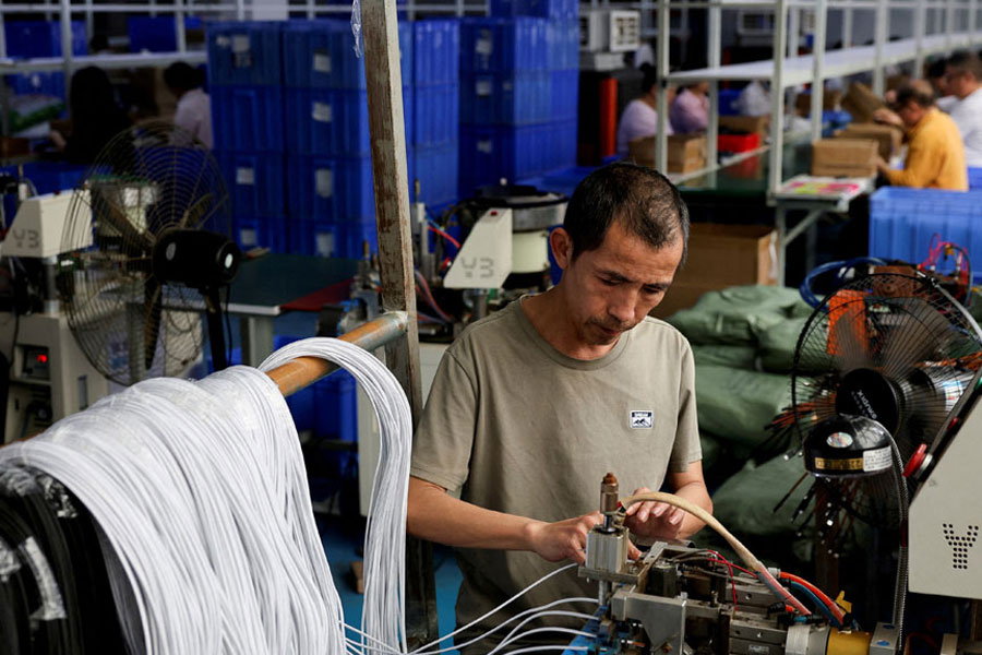 An employee works on USB cables production at a plastic accessories factory, as rising oil prices drive up production costs for plastic manufacturers, in Dongguan, Guangdong province, China, Apr 2, 2026.