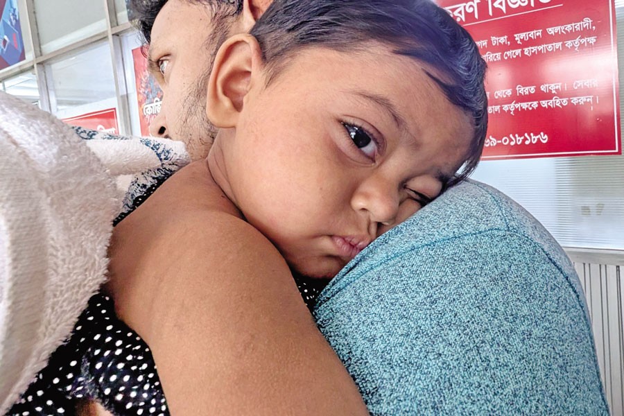 A measles-infected child rests on his father's shoulder as they wait to seek treatment at DNCC Covid Hospital in the city, which is now admitting only patients with measles or measles-like symptoms — FE file photo