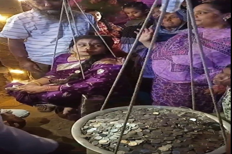 A bride sits on one side of a traditional weighing scale while around 70.3 kilograms of coins are placed on the other. Her grandfather gifts her the coins at her wedding fulfilling a 23-year-old promise. Photo was taken in the Thanthania area of Bogura town. — FE Photo