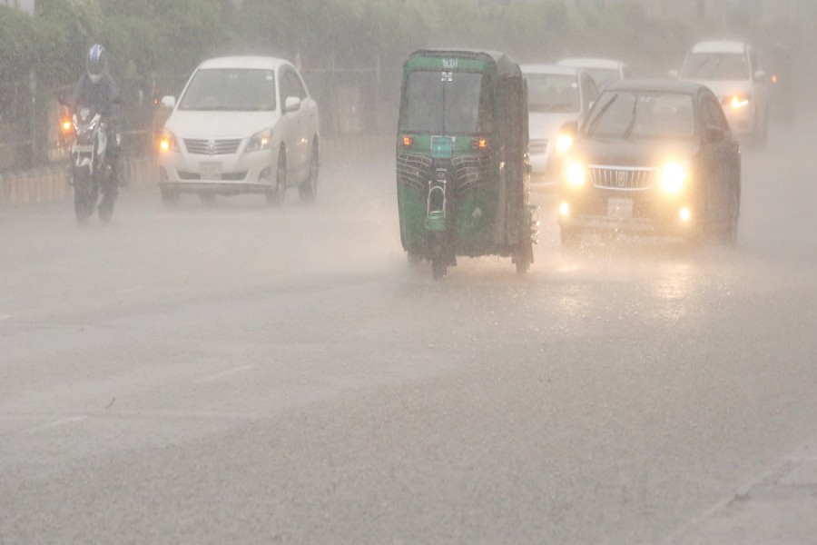 Vehicles move cautiously through heavy rain in the capital's Kakoli area, where dark skies made it appear like night even at around 3:00pm on Saturday, causing suffering for city dwellers. — FE Photo by K Asad-Uz-Zaman
