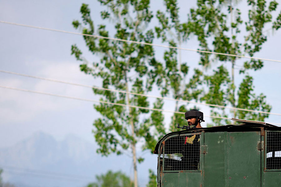 An Indian Army soldier looks out from an armoured vehicle on a highway leading to South Kashmir's Pahalgam, following a suspected militant attack, in Marhama village, in Kashmir, Apr 23, 2025.