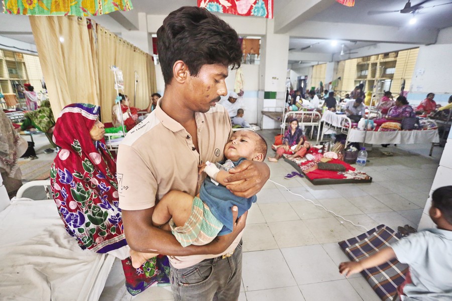 A man holds a child receiving treatment for measles at Mugda Medical College and Hospital in the capital on Sunday, as nationwide death toll from measles and measles-like symptoms crossed 400 after 11 more children died in the last 24 hours until Sunday. — FE Photo by K Asad-Uz-Zaman