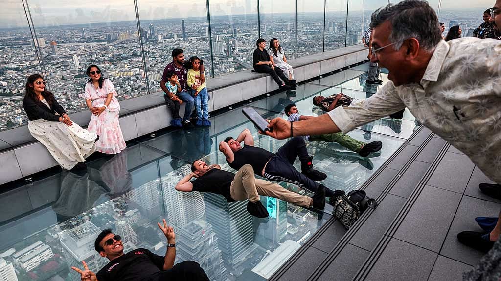 FILE PHOTO: Tourists pose as they enjoy the Mahanakhon Skywalk Rooftop at Mahanakhon building in Bangkok, Thailand, May 15, 2025. REUTERS/Athit Perawongmetha/File Photo