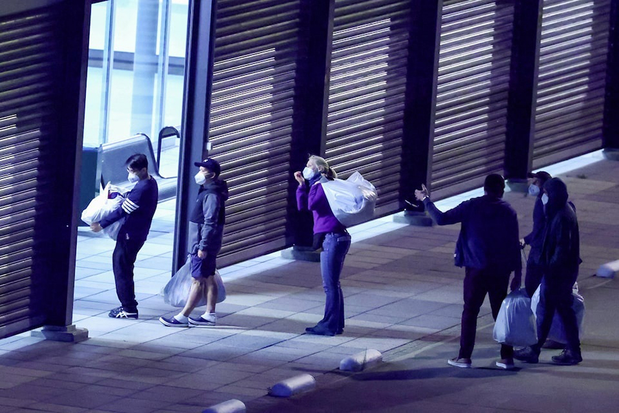 Passengers evacuated from the cruise ship MV Hondius, which was affected by a hantavirus outbreak, walk with their belongings after disembarking at Eindhoven Air Base, Netherlands, on May 12, 2026 — Reuters photo