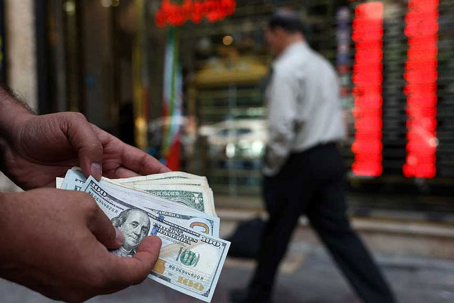 A currency dealer holds one-hundred-dollar bills, as the value of the Iranian rial drops, in Tehran, Iran, May 2, 2026.