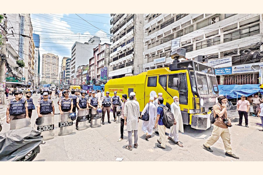 Police stand guard as members of the Conscious Customer Forum form a human chain outside the Islami Bank Bangladesh headquarters in the capital's Motijheel on Monday to protest against the bank's newly-appointed chairman. — FE photo by Shafiqul Alam