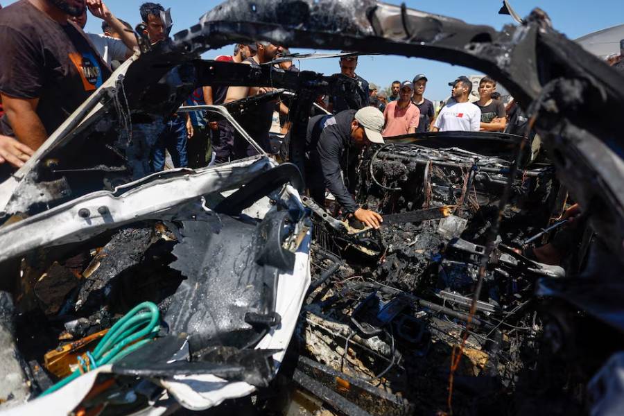 Palestinians inspect a destroyed vehicle at the site of an Israeli strike, in Deir al-Balah, in the central Gaza Strip June 2, 2026.
