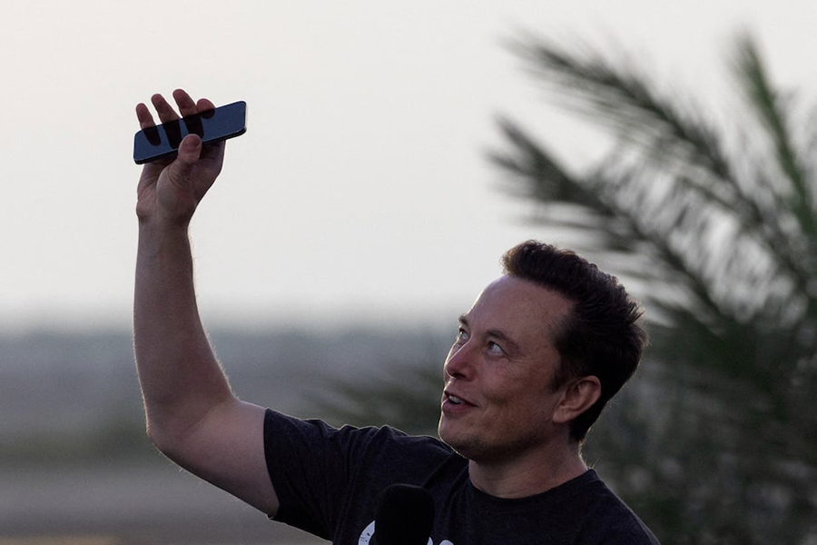 Elon Musk raises his phone towards the sky during a joint news conference with T-Mobile CEO Mike Sievert (not pictured) at the SpaceX Starbase, in Brownsville, Texas, US, on August 25, 2022 — Reuters/File