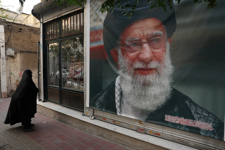 A woman walks past a banner with a picture of the late Iran's Supreme Leader Ayatollah Ali Khamenei, on a street in Tehran, Iran on June 7, 2026 — WANA (West Asia News Agency) via REUTERS