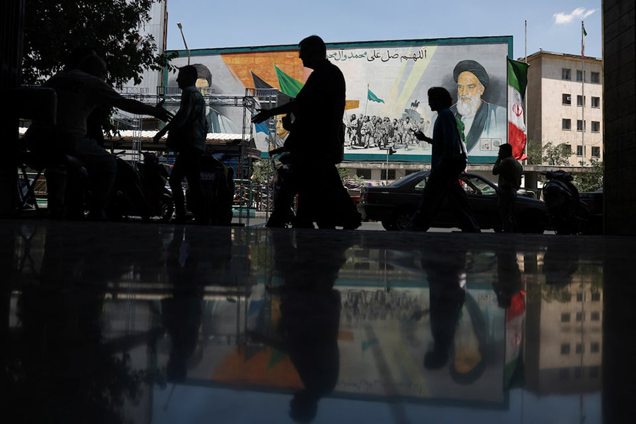People walk near a mural depicting the late leader of the Islamic Revolution, Ayatollah Ruhollah Khomeini, and Iran's late Supreme Leader Ayatollah Ali Khamenei, on a street in Tehran, Iran, on June 14, 2026 — WANA (West Asia News Agency) via REUTERS